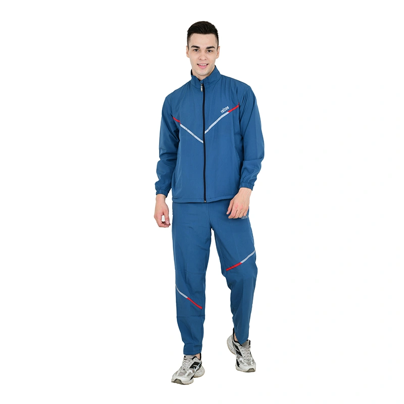 Male model in teal blue tracksuit with red and white stripe accent and grey sneakers - menswear ecommerce photography by Lohar Studio Delhi
